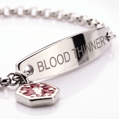 Close-up of the BLOOD THINNER plate on the silver bracelet